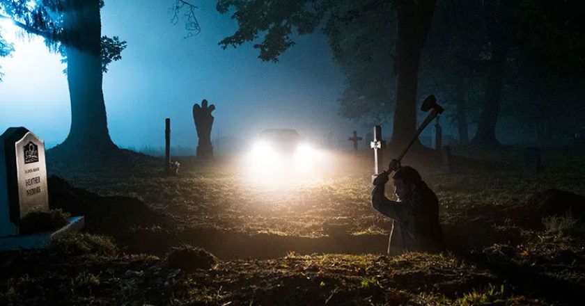 Still from "50 States of Fright" featuring a man digging a grave