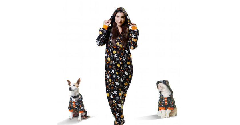 Woman wearing the Bootique Human Printed Pajama Onesie aloing with a dog and cat wearing the matching printed pajamas