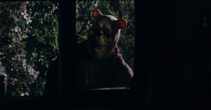 Winnie-the-Pooh looks through a window at night