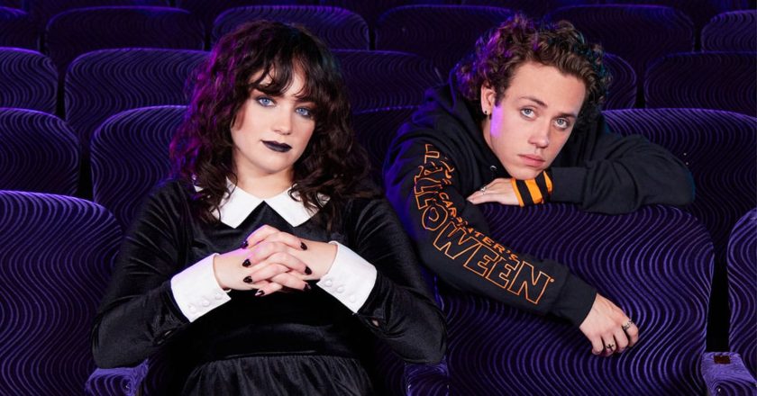 Mary Mouser and Ethan Cutkosky sit in a movie theater